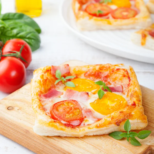 Fresh homemade square Pizza with vegetables and basil on cutting board