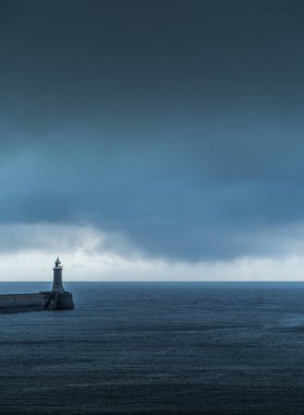 Şafak vakti Tyne Nehri 'nden Kuzey Denizi' ne bakarken büyük gri yağmur bulutları rıhtımda beliriyor.
