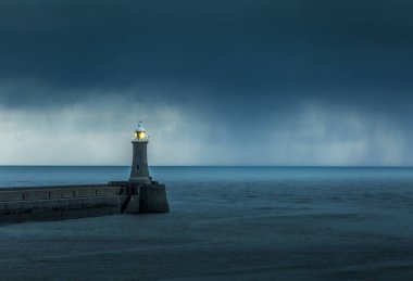 Şafak vakti Tyne Nehri 'nden Kuzey Denizi' ne bakarken büyük gri yağmur bulutları rıhtımda beliriyor.