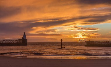 Northumberland 'daki Blyth sahilinde muhteşem bir sabah. Kuzey Denizi' ne uzanan eski ahşap iskele üzerinde güzel bir gün doğumu.
