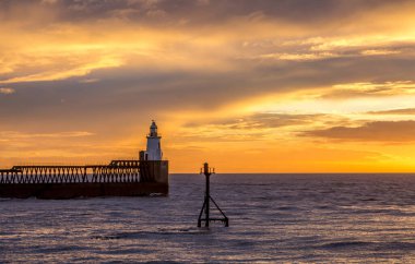 Northumberland 'daki Blyth sahilinde muhteşem bir sabah. Kuzey Denizi' ne uzanan eski ahşap iskele üzerinde güzel bir gün doğumu.