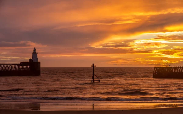 Northumberland 'daki Blyth sahilinde muhteşem bir sabah. Kuzey Denizi' ne uzanan eski ahşap iskele üzerinde güzel bir gün doğumu.