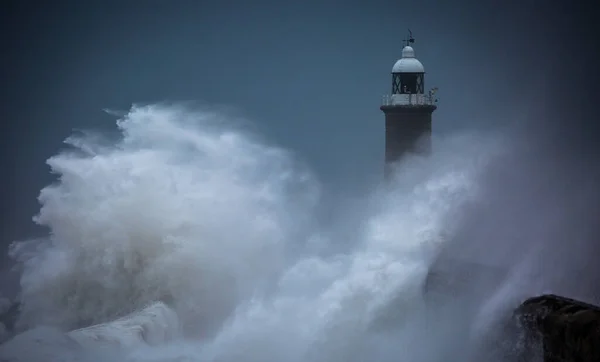 Giant waves batter the lighthouse & north pier guarding the mouth of the Tyne in Tynemouth, England