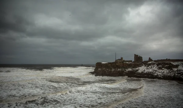 Dev dalgalar, Tynemouth Manastırı 'nın etrafındaki uçurumlar karla kaplanırken, kış fırtınası sırasında Kral Edward' s Bay 'i vuruyor.