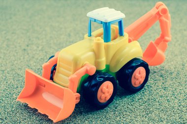 Traktör beko oyuncak kum zemin üzerine.