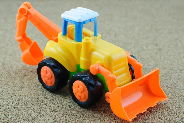 Tractor backhoe toy on sand background. — Stock Photo, Image