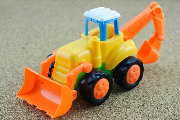 Tractor backhoe toy on sand background. — Stock Photo, Image