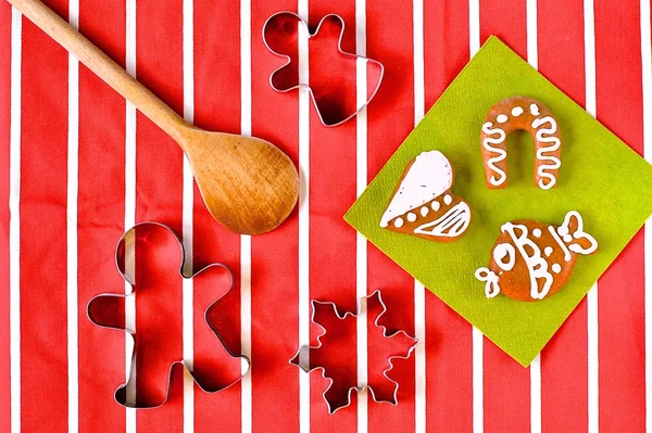 Tahta kaşık ve Noel tatlılar üzerinde kırmızı-beyaz çizgili masa örtüsü