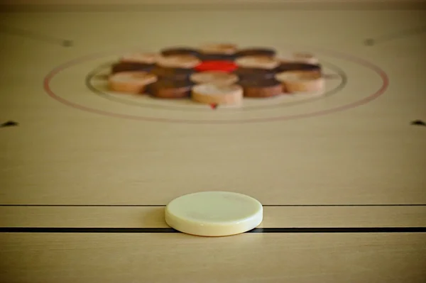 Carrom striker and black and white coins — Stock Photo, Image