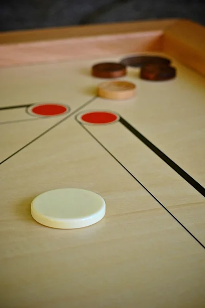 Carrom striker with black and white coins — Stock Photo, Image