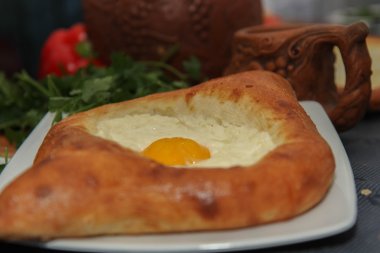 Khachapuri by Adzharia (Georgian cheese pastry), filled with cheese and topped with a soft-boiled egg and butter