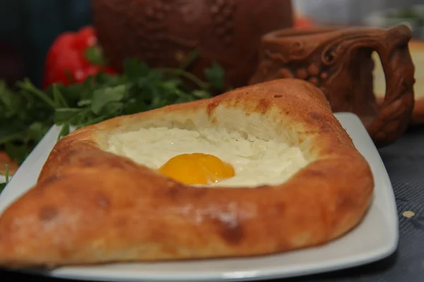 Khachapuri tarafından Adzharia (Gürcü peynir pasta), peynir ile doldurulmuş ve rafadan yumurta ve tereyağı ile tepesinde