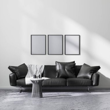 Modern minimalist tarzlı oturma odasının içinde siyah kanepe ve 3D resimli poster çerçeveleri.