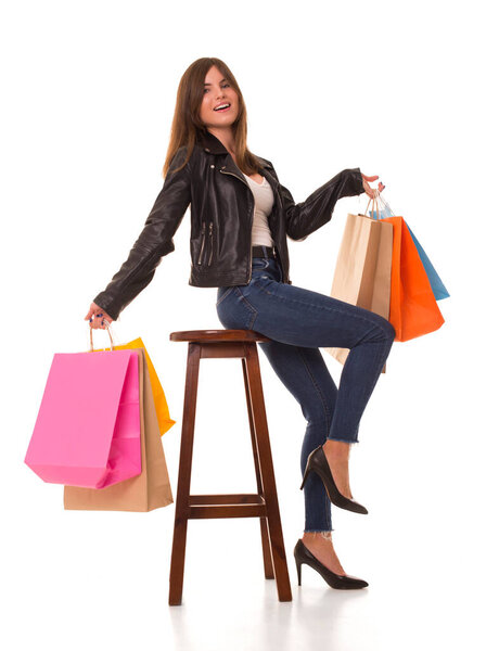 Girl sitting on a chair with purchases in hands. 