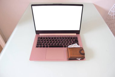 Dolarla dolu cüzdan dizüstü bilgisayarda duruyor..