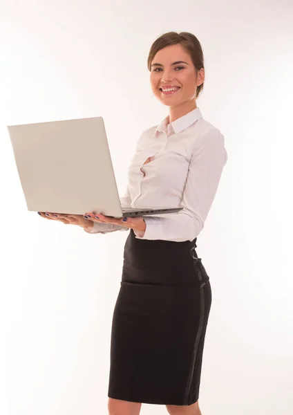 Beautiful girl stands on a white with a laptop. — Stock Photo, Image