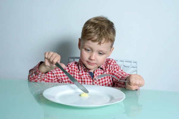 Mały chłopiec jedzący małą porcję jedzenia. — Zdjęcie stockowe
