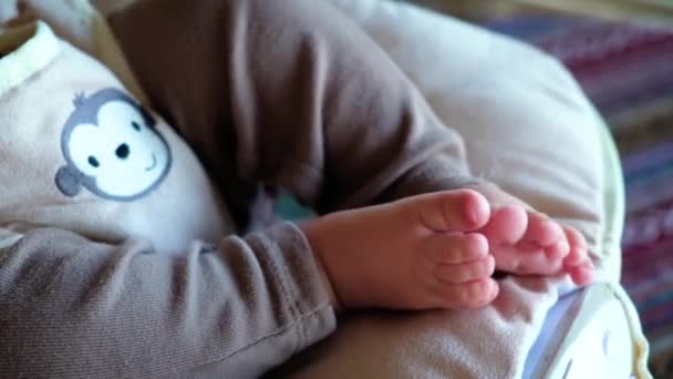 Bonito recém-nascido bebê pés close-up em uma cadeira de crianças vibro — Vídeo de Stock