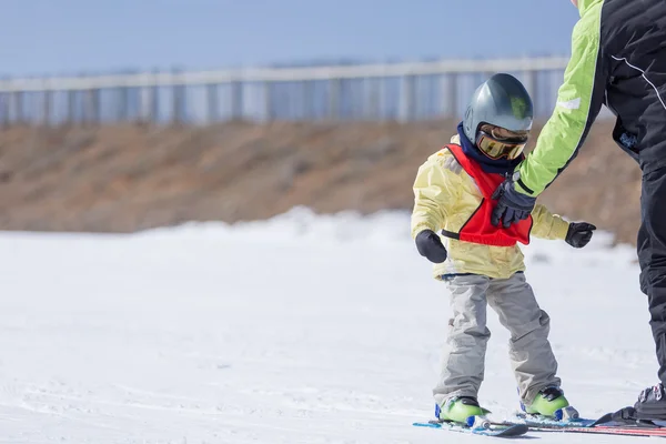 Чоловік навчає сина кататися на лижах — стокове фото