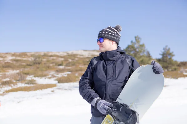 Man håller snowboard i snö — Stockfoto