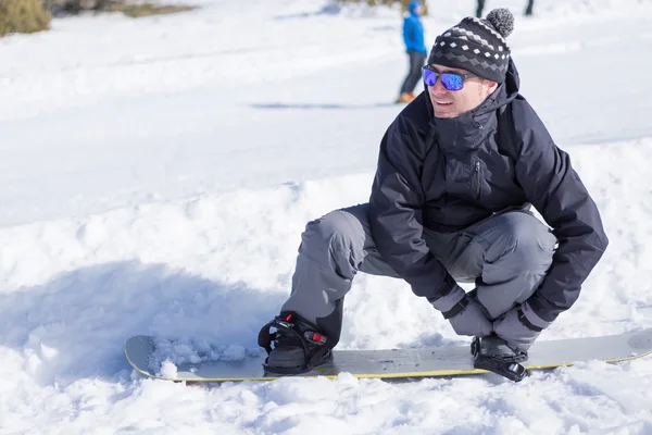 Человек надевает сноуборд — стоковое фото