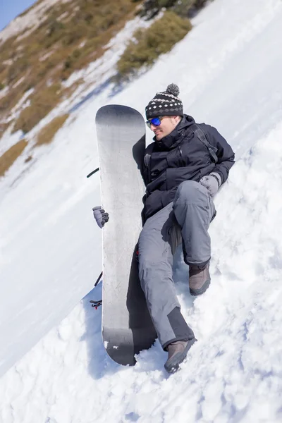 Avslappnad snowboardåkare med snowboard — Stockfoto