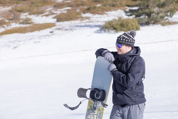 Smiling man in hat and sunglasses with snowboard — Stock Photo, Image