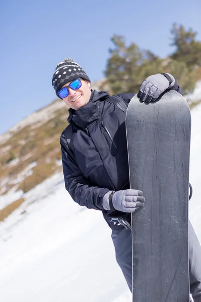 Χαμογελαστός άνθρωπος σε γυαλιά ηλίου με snowboard — Φωτογραφία Αρχείου