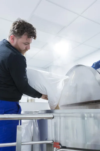 Arbetstagaren att lägga till malt i panna — Stockfoto