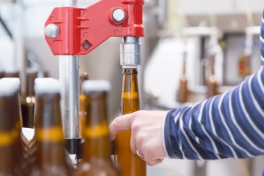 Şişeler ve kapanma için ekipman kullanan adam