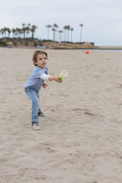 Cute boy catching small orange ball — Stock Photo, Image