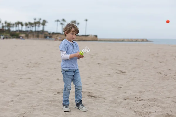 Lovely bot olhando para voar bola laranja — Fotografia de Stock