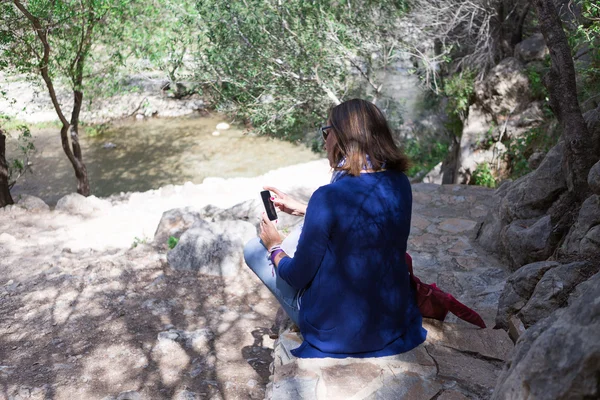 Mujer joven con teléfono celular en el parque — Foto de Stock