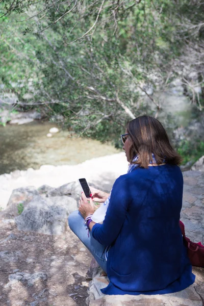 Γυναίκα με κινητό τηλέφωνο στο πάρκο — Φωτογραφία Αρχείου