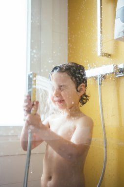 Su duş yaparken yüzünü dökme küçük çocuk