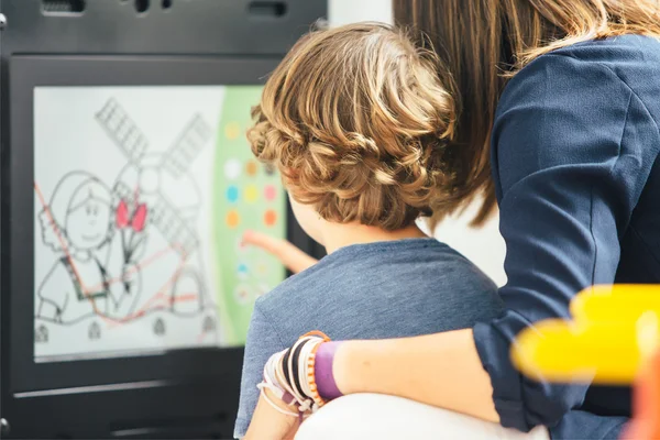 Vista posterior del niño con madre aprendiendo a pintar —  Fotos de Stock