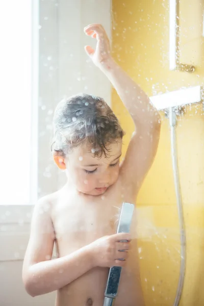 Söt liten pojke med dusch i dagsljus — Stockfoto