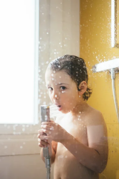 Mały chłopiec wylewanie wody w ustach mając prysznic — Zdjęcie stockowe