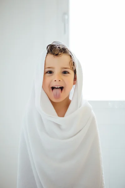 Lovely kid in towel sticking out tongue — Stock Photo, Image