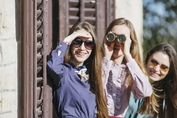 Femmes souriantes regardant à travers les jumelles — Photo