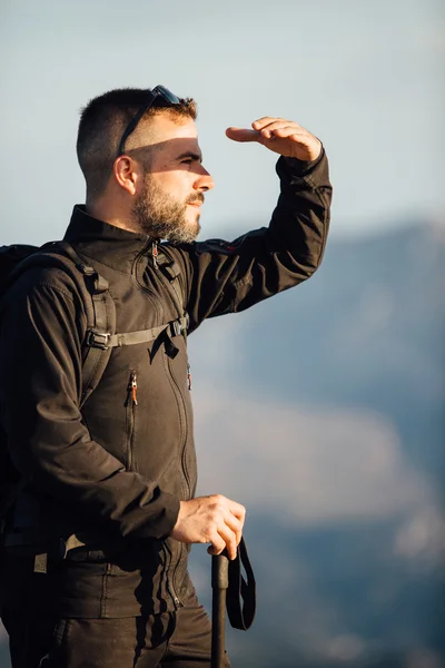 Ορειβάτης ψάχνει μακριά με το χέρι, η προστασία των ματιών — Φωτογραφία Αρχείου