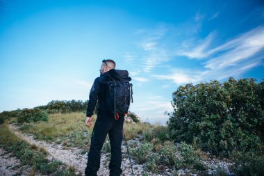 Gezgin dağ yolu üzerinde sırt çantası ile