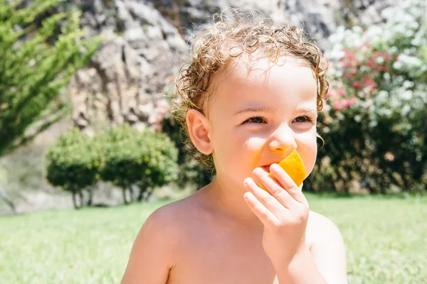 Miúdo bonito comendo frutas — Fotografia de Stock