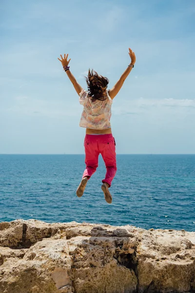 Mujer feliz saltando contra el mar — Foto de Stock