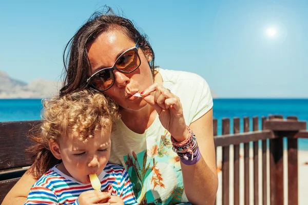 Familia comiendo helado contra el mar Fotos de stock