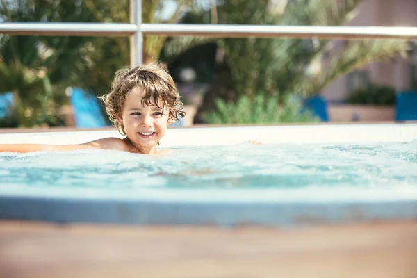 Sorrindo menino desfrutando jacuzzi — Fotografia de Stock