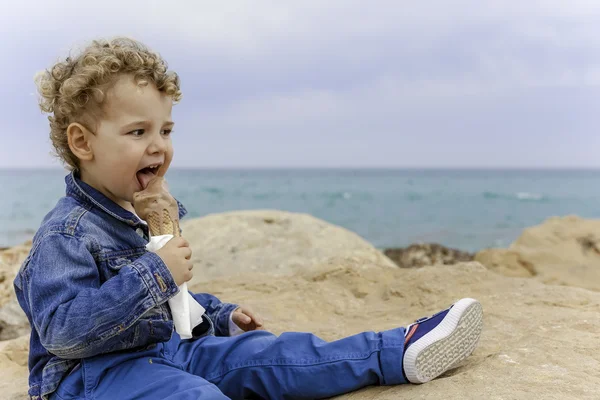 Enfant manger une crème glacée sur la plage — Photo