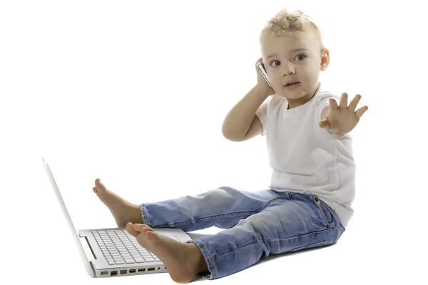 Niño usando un teléfono móvil y una computadora portátil — Foto de Stock