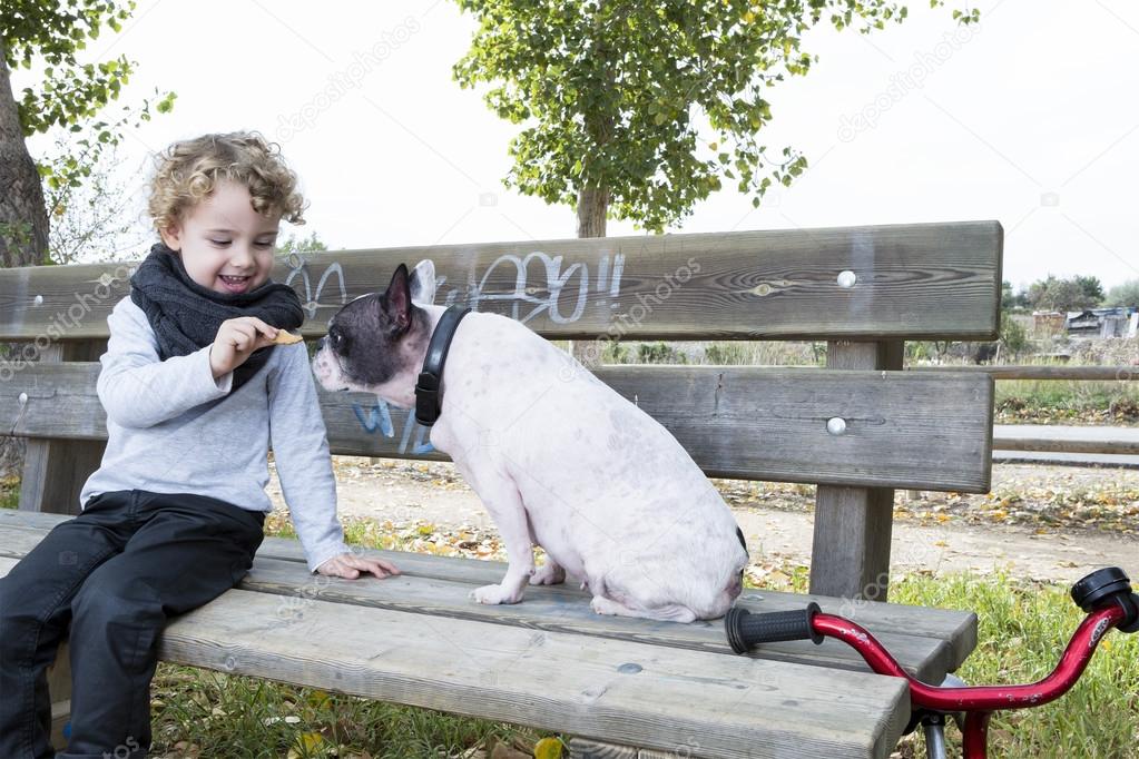 child giving his dog a biscuit