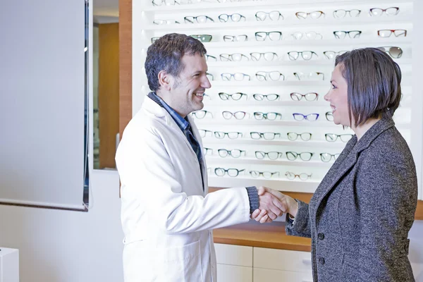 Optician is welcoming to a customer — Stock Photo, Image